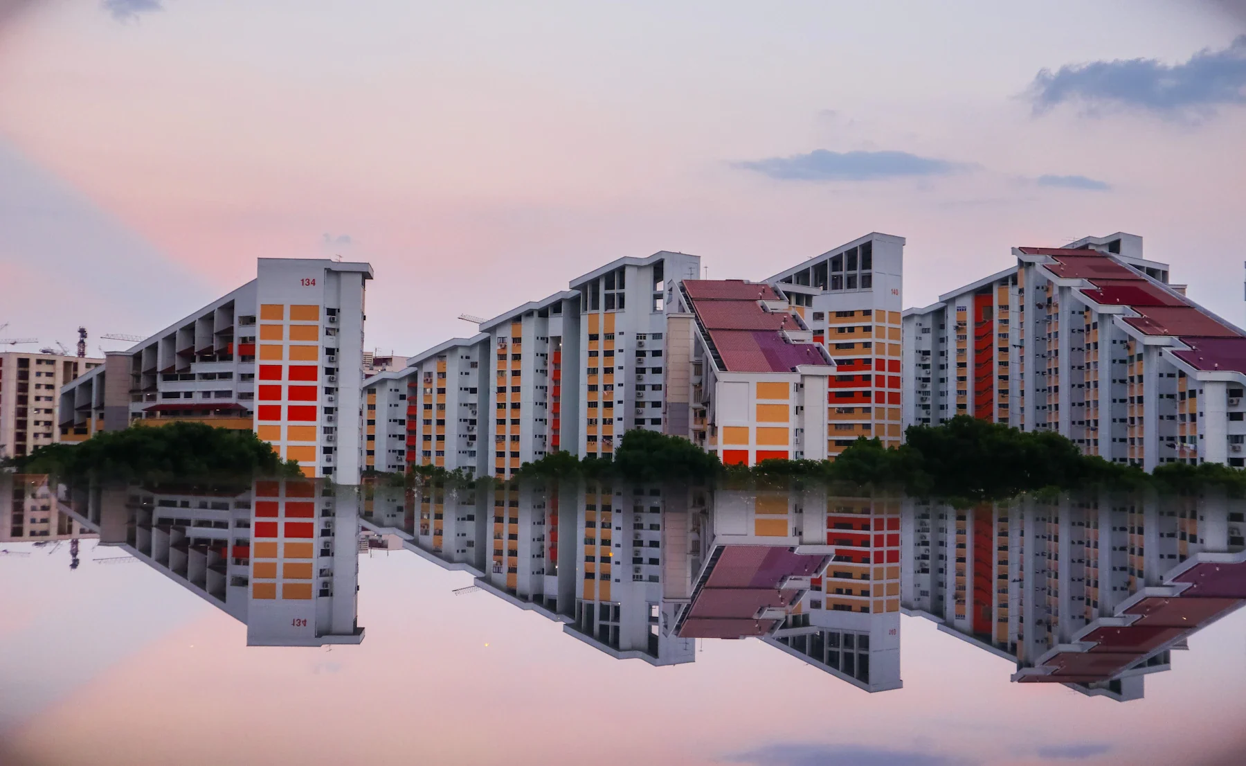 Singapore residential towers reflected in still water at sunset